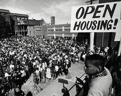 Rally for fair housing in Milwaukee 1967. Protestor in foreground holding "OPEN HOUSING" sign. 