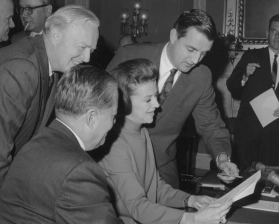 Special Assistant for Consumer Affairs Betty Furness reviews a Senate bill with Senator Walter Mondale and others; 