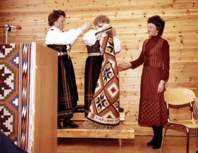 Joan Mondale in Norway being presented a weaving from two women